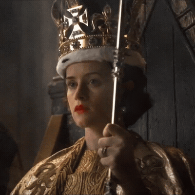 A Woman Is Wearing A Crown And Holding A Scepter GIF