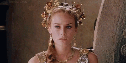 A Woman Is Wearing A Crown Of Flowers On Her Head . GIF