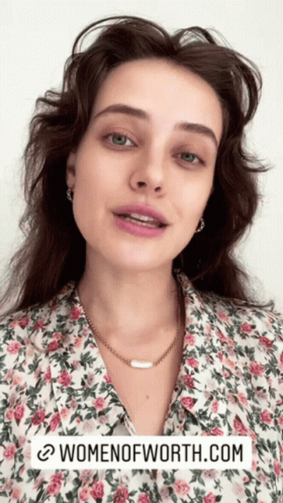 A Woman Is Wearing A Floral Shirt And A Necklace With The Website Womenofworth.com Written Below Her GIF