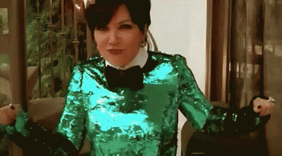 A Woman Is Wearing A Green Sequined Top And A Black Bow Tie GIF