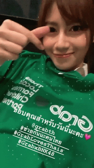 A Woman Is Wearing A Green Shirt That Says Grabth GIF