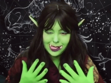 A Woman Is Wearing A Green Wig And Green Gloves . GIF