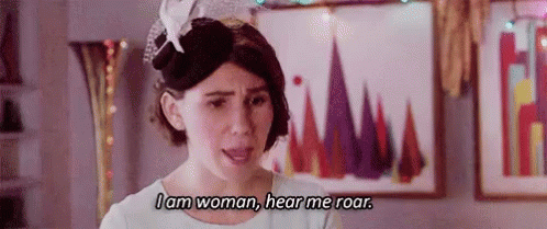 A Woman Is Wearing A Hat And A White Dress And Says `` I Am Woman , Hear Me Roar '' . GIF