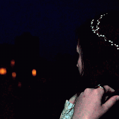 A Woman Is Wearing A Headband With White Beads On It GIF
