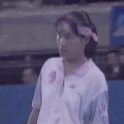 A Woman Is Wearing A Pink Headband And A White Shirt . GIF