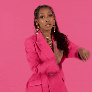 A Woman Is Wearing A Pink Jacket And Earrings . GIF