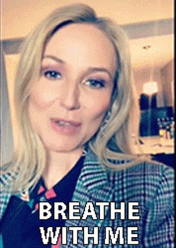 A Woman Is Wearing A Plaid Jacket With The Words Breathe With Me Written On It GIF