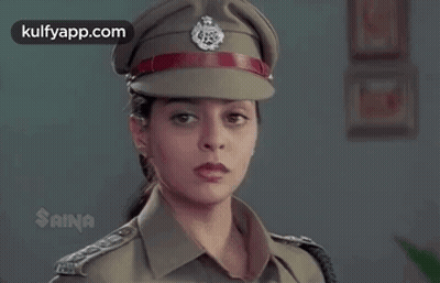 A Woman Is Wearing A Police Uniform And Hat . GIF