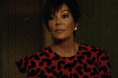 A Woman Is Wearing A Red And Black Dress With Hearts On It . GIF