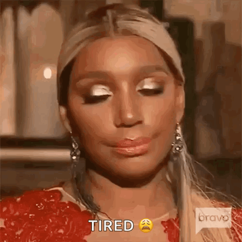 A Woman Is Wearing A Red Dress And Earrings And Making A Tired Face . GIF