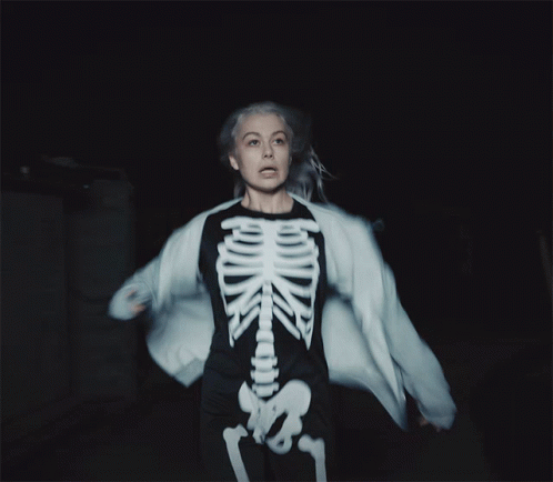 A Woman Is Wearing A Skeleton Costume And A White Jacket GIF