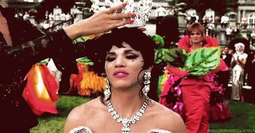 A Woman Is Wearing A Tiara And A Necklace GIF
