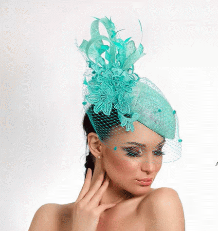 A Woman Is Wearing A Turquoise Hat With A Veil GIF