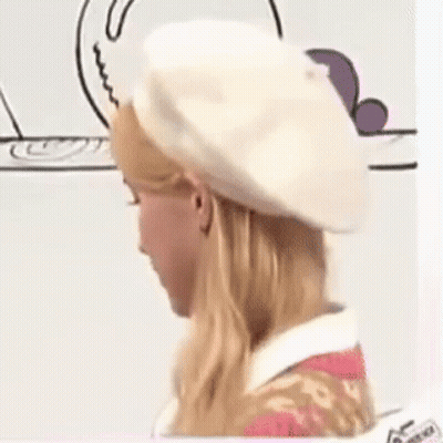 a woman is wearing a white beret and a pink dress .