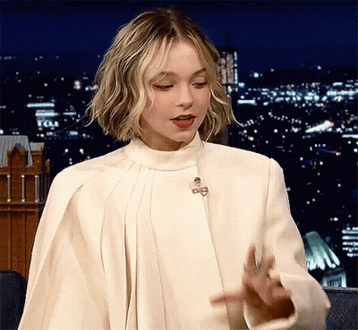 A Woman Is Wearing A White Coat With A Collar And A Cape .. GIF