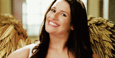 A Woman Is Wearing Angel Wings And Smiling For The Camera GIF