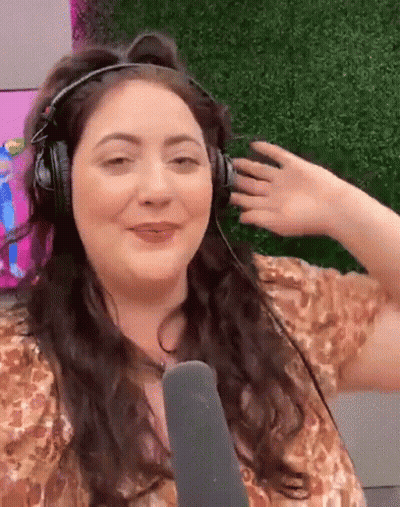 A Woman Is Wearing Headphones And A Microphone And Making A Funny Face GIF