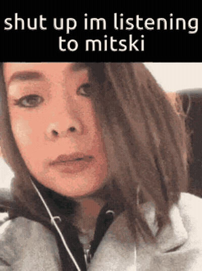 A Woman Is Wearing Headphones And Says Shut Up Im Listening To Mitski . GIF