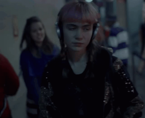 A Woman Is Wearing Headphones And Singing Into A Microphone GIF