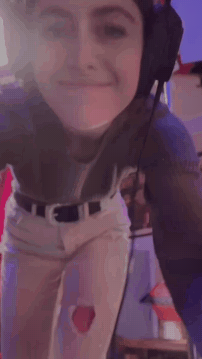 A Woman Is Wearing Headphones And Smiling While Dancing . GIF