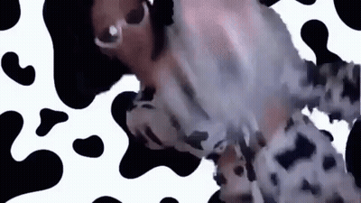 A Woman Is Wearing Sunglasses And A Cow Print Dress . GIF
