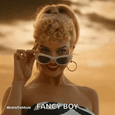 A Woman Is Wearing Sunglasses And Smiling While Standing On A Beach . GIF