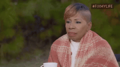 A Woman Is Wrapped In A Blanket And Holding A Cup . GIF