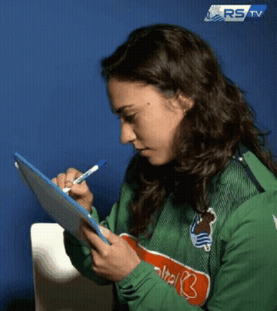 A Woman Is Writing On A Clipboard With A Pen . GIF