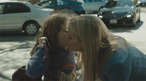 A Woman Kisses A Little Girl On The Cheek GIF