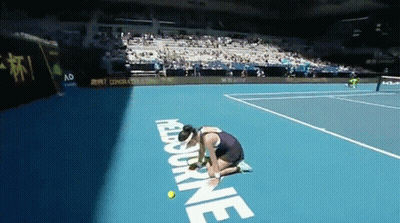 A Woman Kneeling Down On A Tennis Court With The Word Melbourne On The Ground GIF