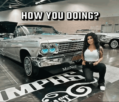 A Woman Kneeling In Front Of A Car With The Words How You Doing Written On It GIF