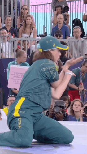 A Woman Kneeling In Front Of A Crowd Holding A Sign That Says ' It 'S Your People ' On It GIF