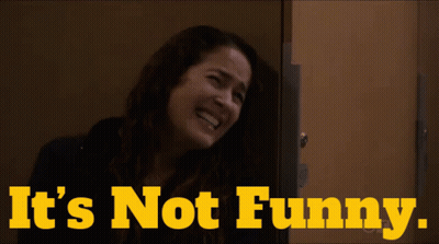 A Woman Laughing With The Words " It 'S Not Funny " Behind Her GIF
