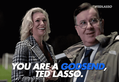 A Woman Laughs Next To A Man Who Says You Are A Godsend GIF