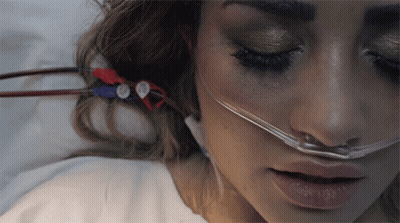 A Woman Laying In A Hospital Bed With An Oxygen Mask On Her Nose GIF