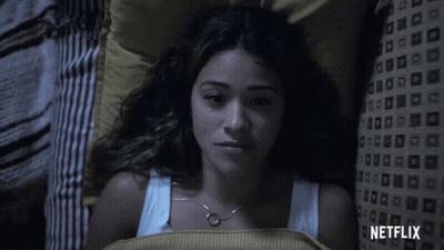 A Woman Laying In Bed With A Netflix Logo On The Bottom GIF