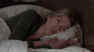 A Woman Laying In Bed With A Pillow On Her Head GIF