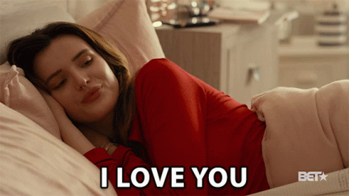 A Woman Laying In Bed With The Words I Love You Written On The Bottom GIF