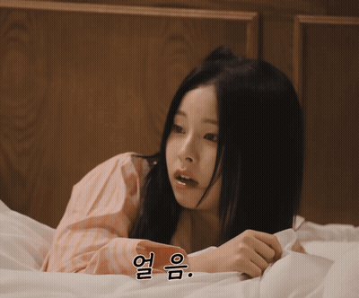 A Woman Laying On A Bed With A Foreign Language Written On The Bottom GIF