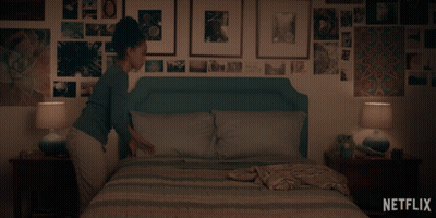 A Woman Laying On A Bed With A Netflix Logo On The Bottom Right GIF