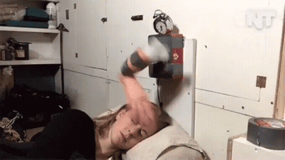 A Woman Laying On A Bed With An Alarm Clock On The Wall Above Her GIF