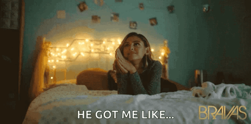 A Woman Laying On A Bed With The Words He Got Me Like Behind Her GIF