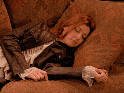 A Woman Laying On A Couch With Her Eyes Closed GIF