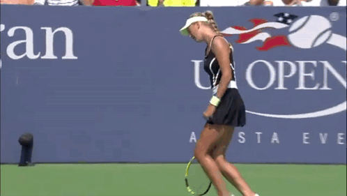 A Woman Laying On A Tennis Court With A Racket GIF