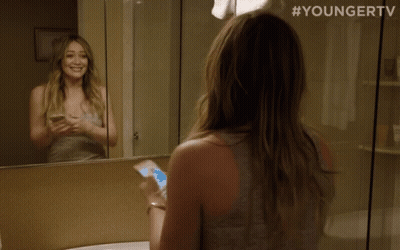 A Woman Looking At Herself In A Bathroom Mirror With #Youngertv On The Bottom GIF