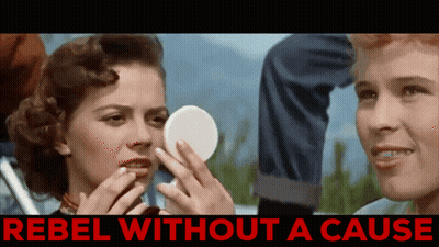 A Woman Looking At Herself In A Mirror With The Words Rebel Without A Cause Below GIF
