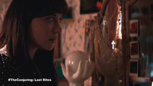 A Woman Looking At Herself In A Mirror With #Theconjuring Last Rites Written On The Bottom GIF