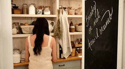A Woman Looking Into A Pantry With A Chalkboard That Says Ready Or Not GIF