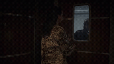 A Woman Looking Out A Window With A Sign That Says Wc GIF