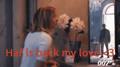 A Woman Looks At Her Reflection In A Mirror With The Words Haf Is Back My Love < 3 GIF